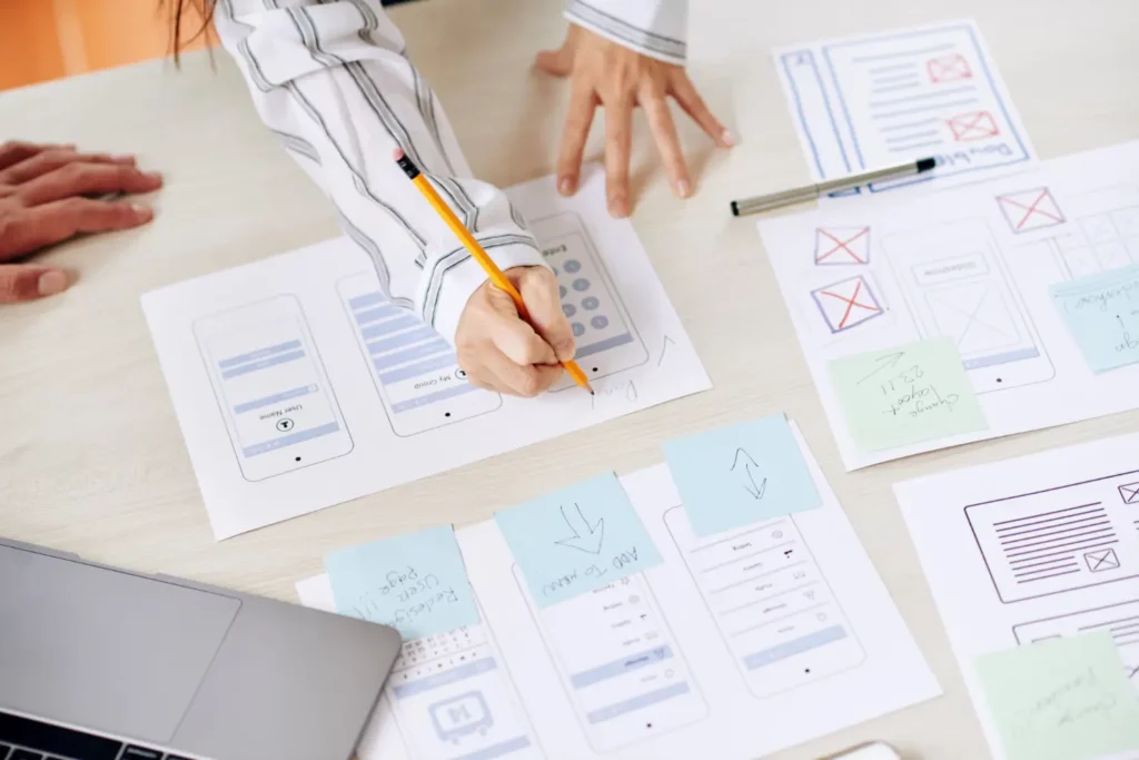principles of user interface design - people drawing designs on desktop and collaborating
